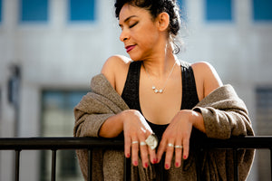 Woman wearing Triple Broken sterling silver necklace with triple silver necklace pendants and multiple silver rings