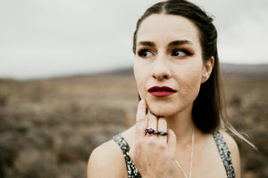 Model wearing red garnet ring, unique light and dark silver bar ring