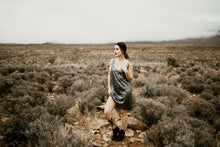 Load image into Gallery viewer, Women in desert wearing Hera Necklace with an oval necklace pendant made of steel, silver, and red garnet