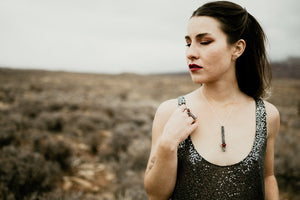 Model wearing matching garnet and silver bar ring and necklace