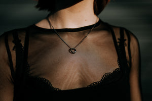 Model wearing dark steel necklace with sterling silver chain